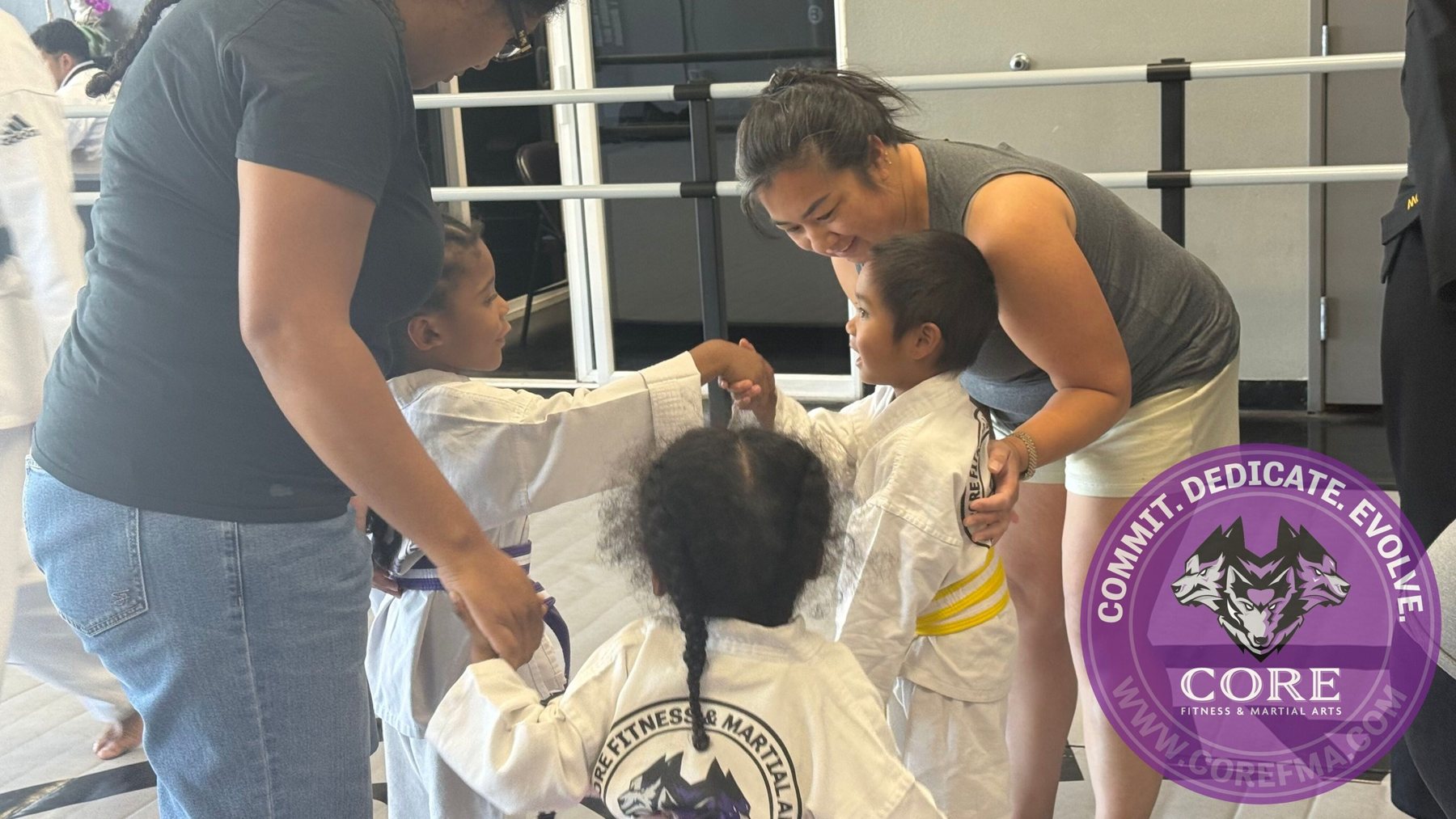 A parent tying her child's belt before class at CORE Fitness & Martial Arts in Henderson