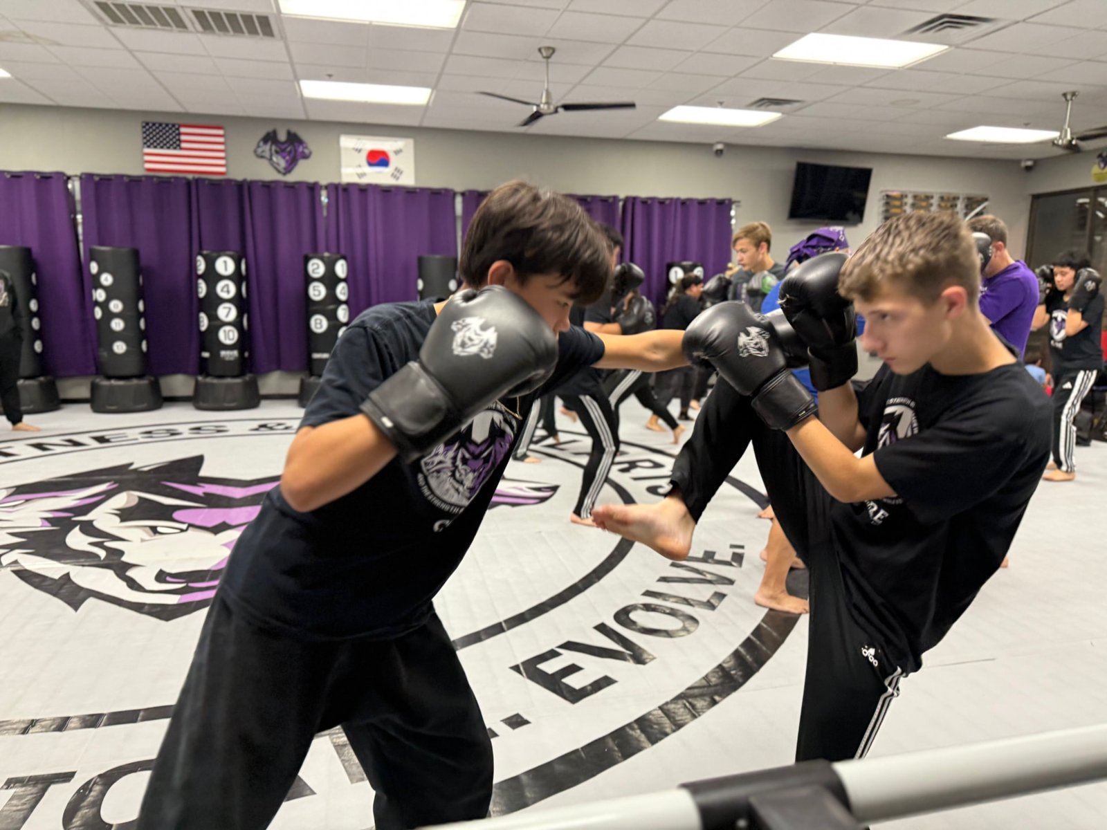 Warrior students sparring with a jumping kick at CORE Fitness & Martial Arts in Henderson