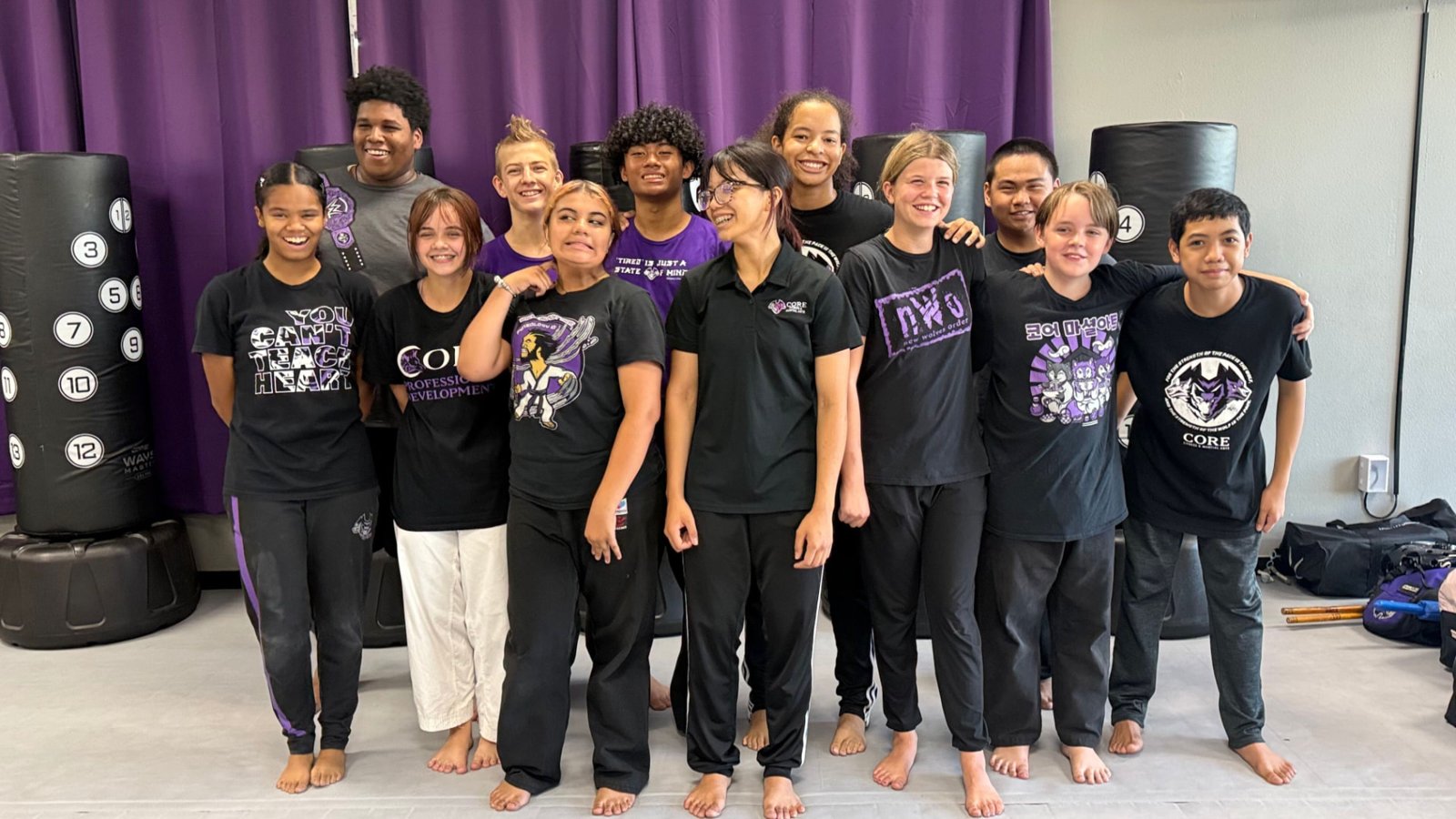 Teen and adult Warrior students in black CORE shirts standing together at CORE Fitness & Martial Arts in Henderson