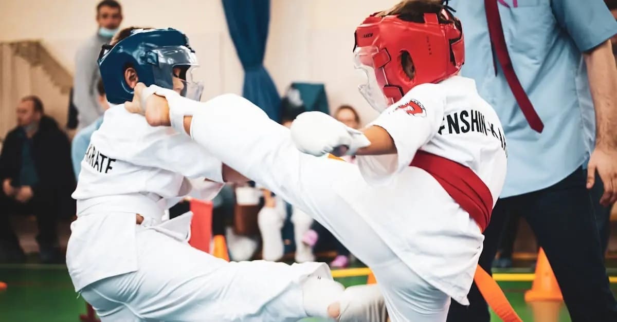 Two students sparring using kicks as part of their daily Taekwondo basics for beginners curriculum.