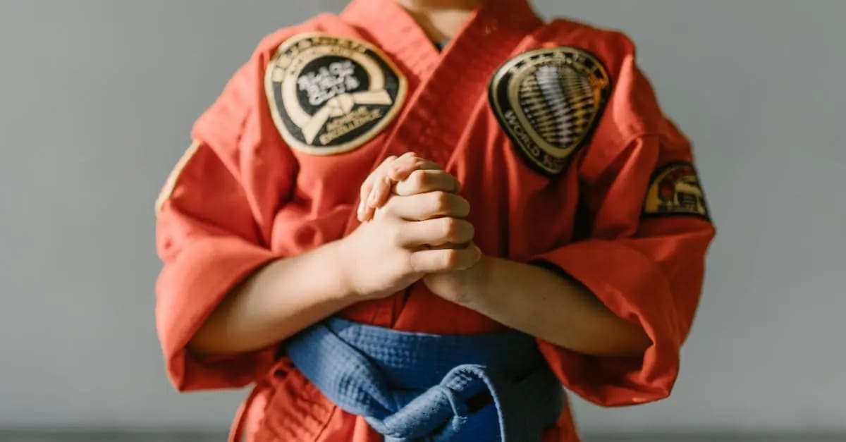 A martial arts student focusing on proper stance while practicing fundamental Taekwondo basics for beginners.
