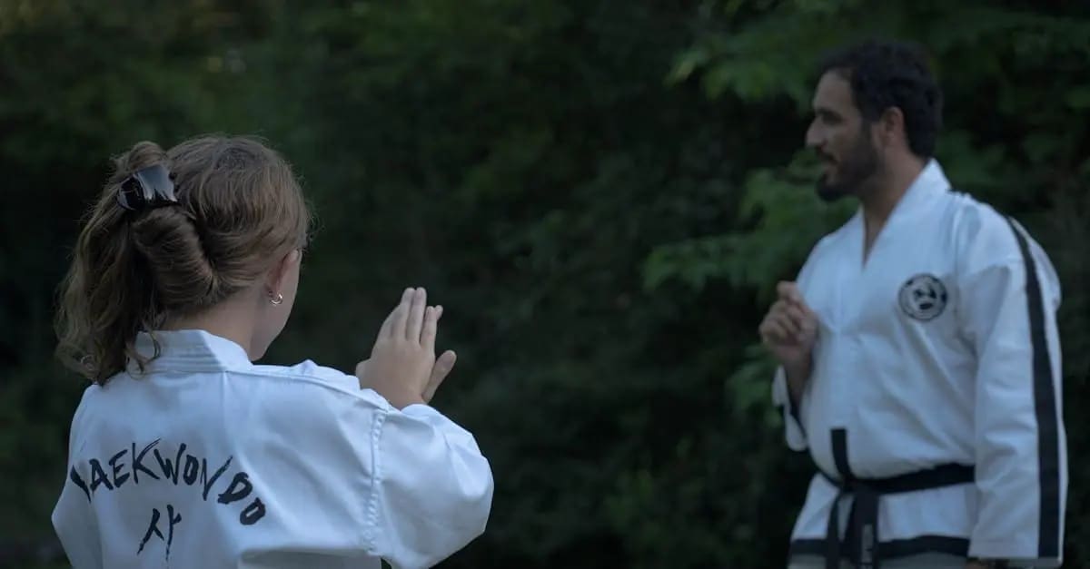 Student performing dynamic stretching and Taekwondo basics for beginners during an outdoor pre-class warm-up routine.